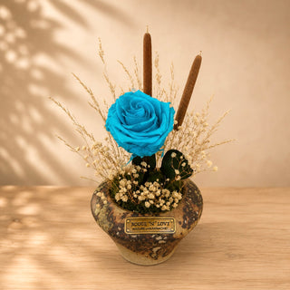 Azur Éternelle Bloom preserved blue rose arrangement with dried botanicals in a decorative pot.