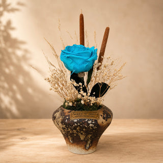 Azur Éternelle Bloom with a preserved blue rose, dried botanicals and preserved florals in a decorative pot.